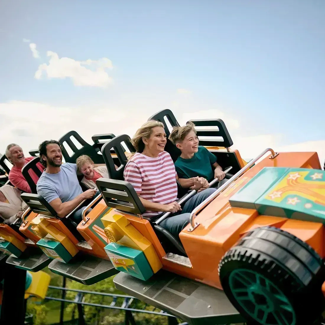 Family smiling riding Minifigure Speedway at the LEGOLAND Windsor Resort